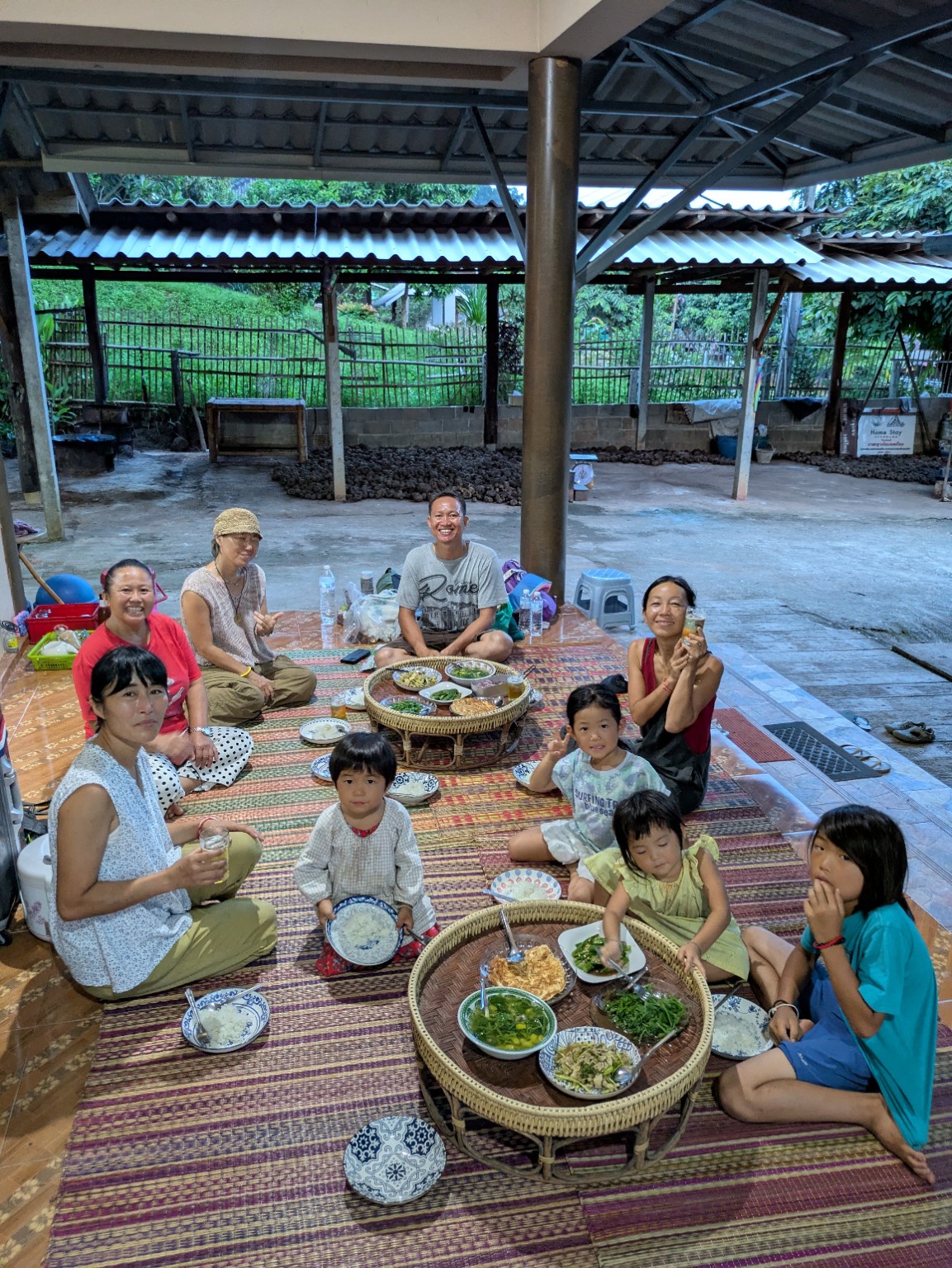 村のみなさんと家族で、タイ・ルー族の料理が並ぶ食卓を囲む